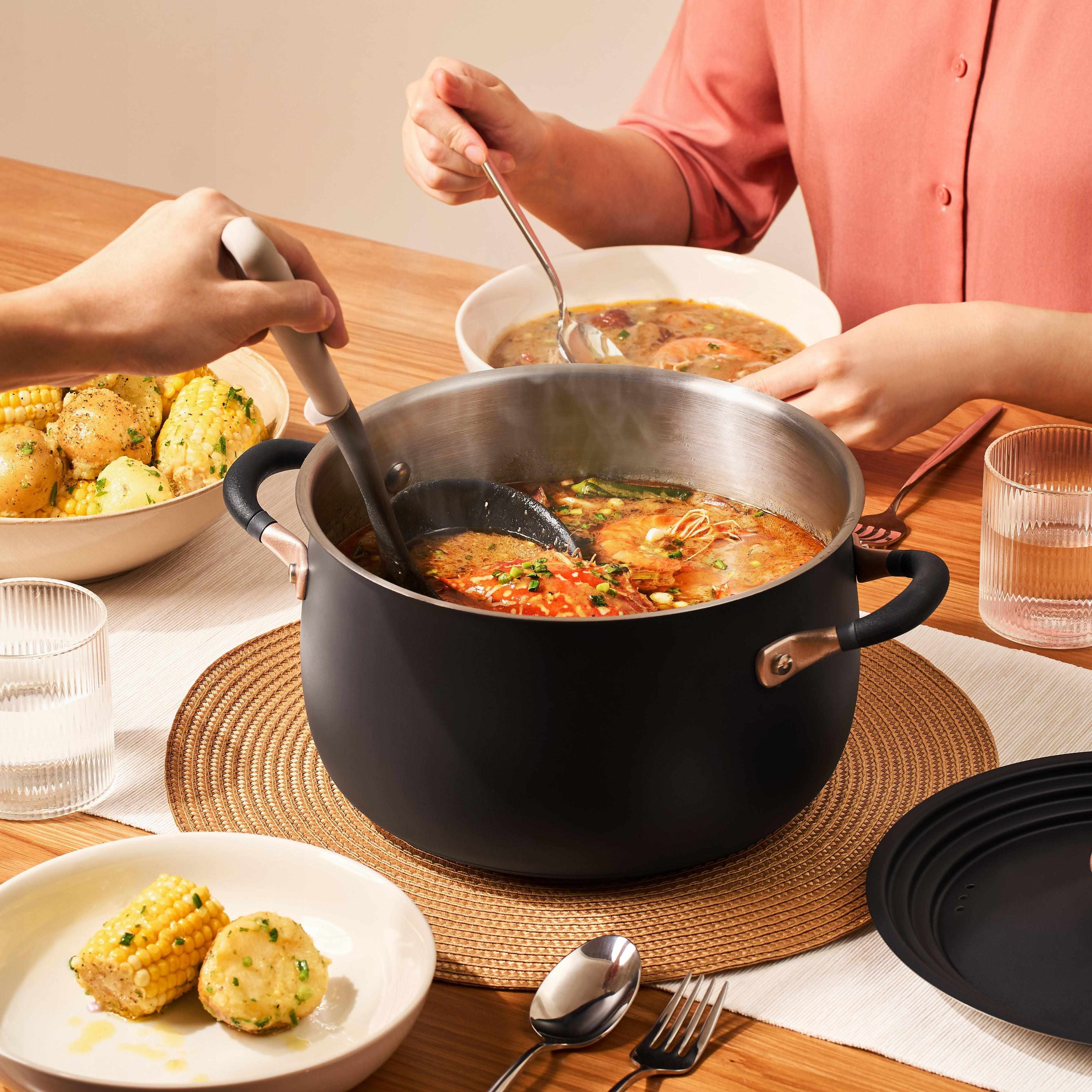 Ladling soup from a acccent medium-sized black Stainless Steel stockpot