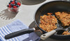 Meyer nonstick skillet with hash browns displayed on a concrete table in an appealing setting
