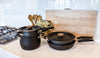 Meyer cookware essential set elegantly arranged on a pristine white kitchen table