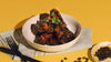 Singaporean-Style Sticky Coffee Pork Ribs elegantly presented in a ceramic bowl accompanied by a beautifully set table