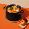 accent large-sized black Stainless Steel stockpot filled with chicken soup and ingredients